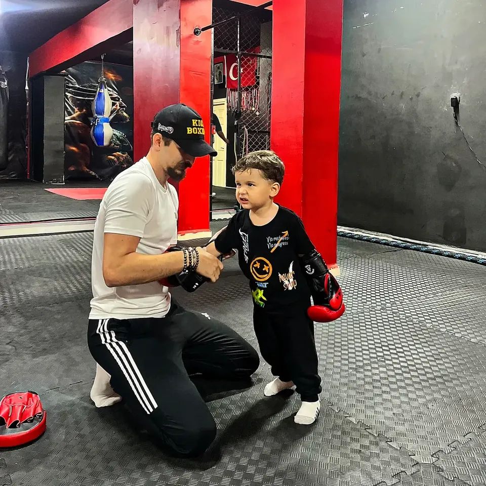 Umut Yasan çocuk sporcunun boks eldivenini düzeltiyor